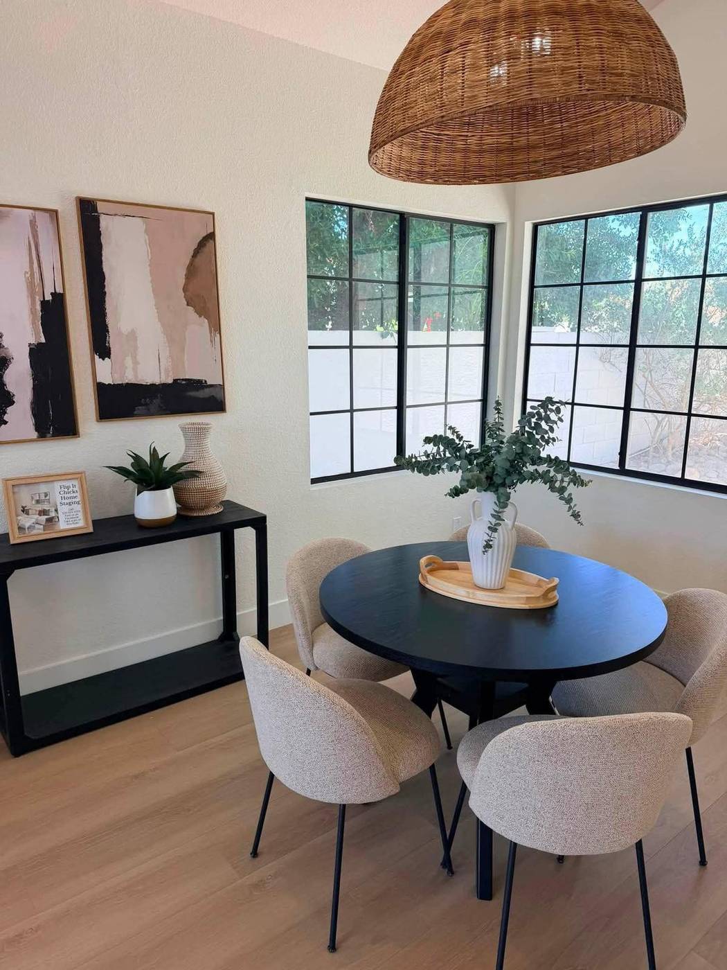 Breakfast nook staged with a round table, rattan pendant and console styling