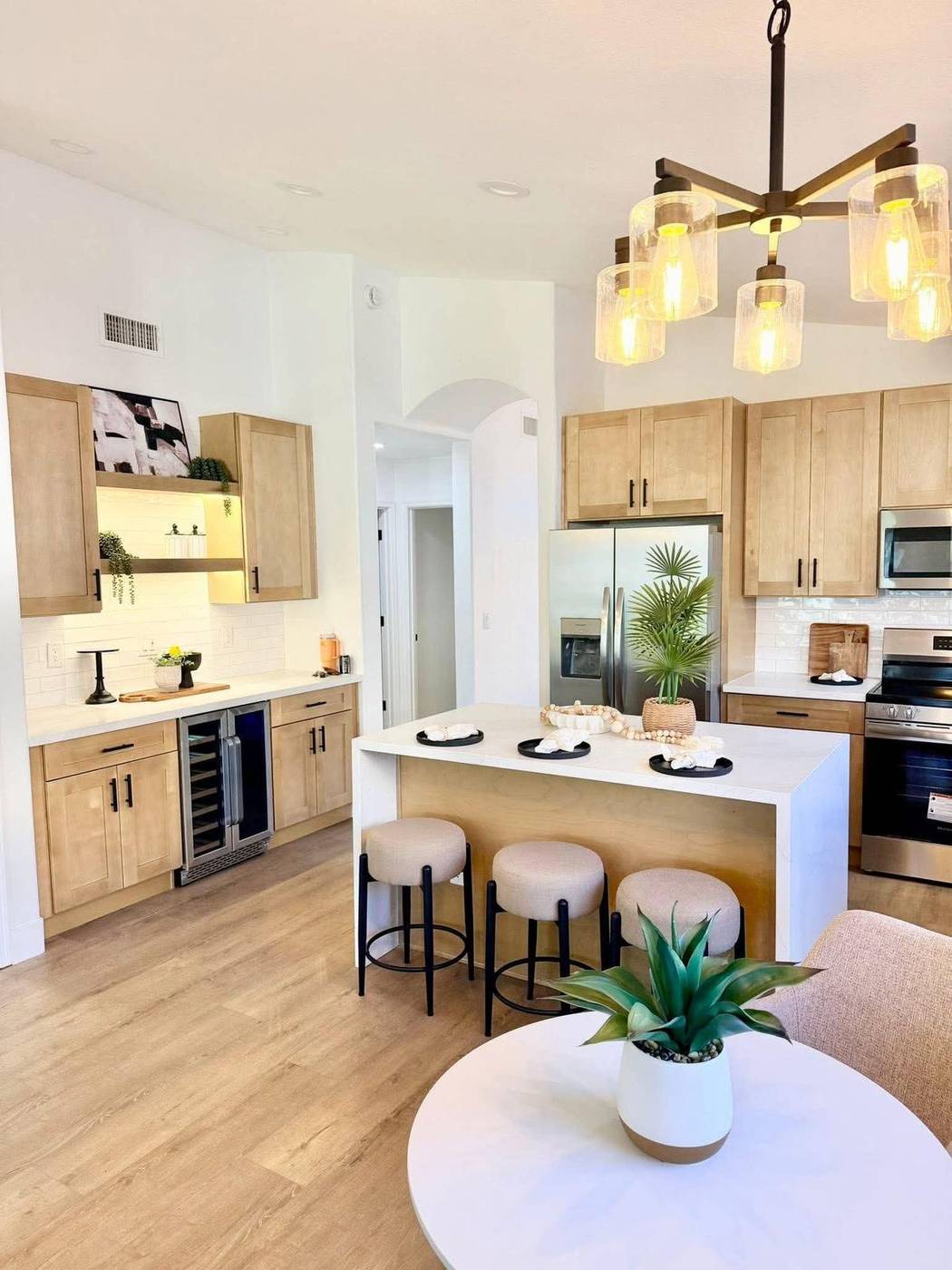 Staged kitchen island with woven barstools and a small dining table in a Gilbert, AZ home under $500,000 Staged kitchen island with woven barstools and a small dining table in a Gilbert, AZ home under $500,000