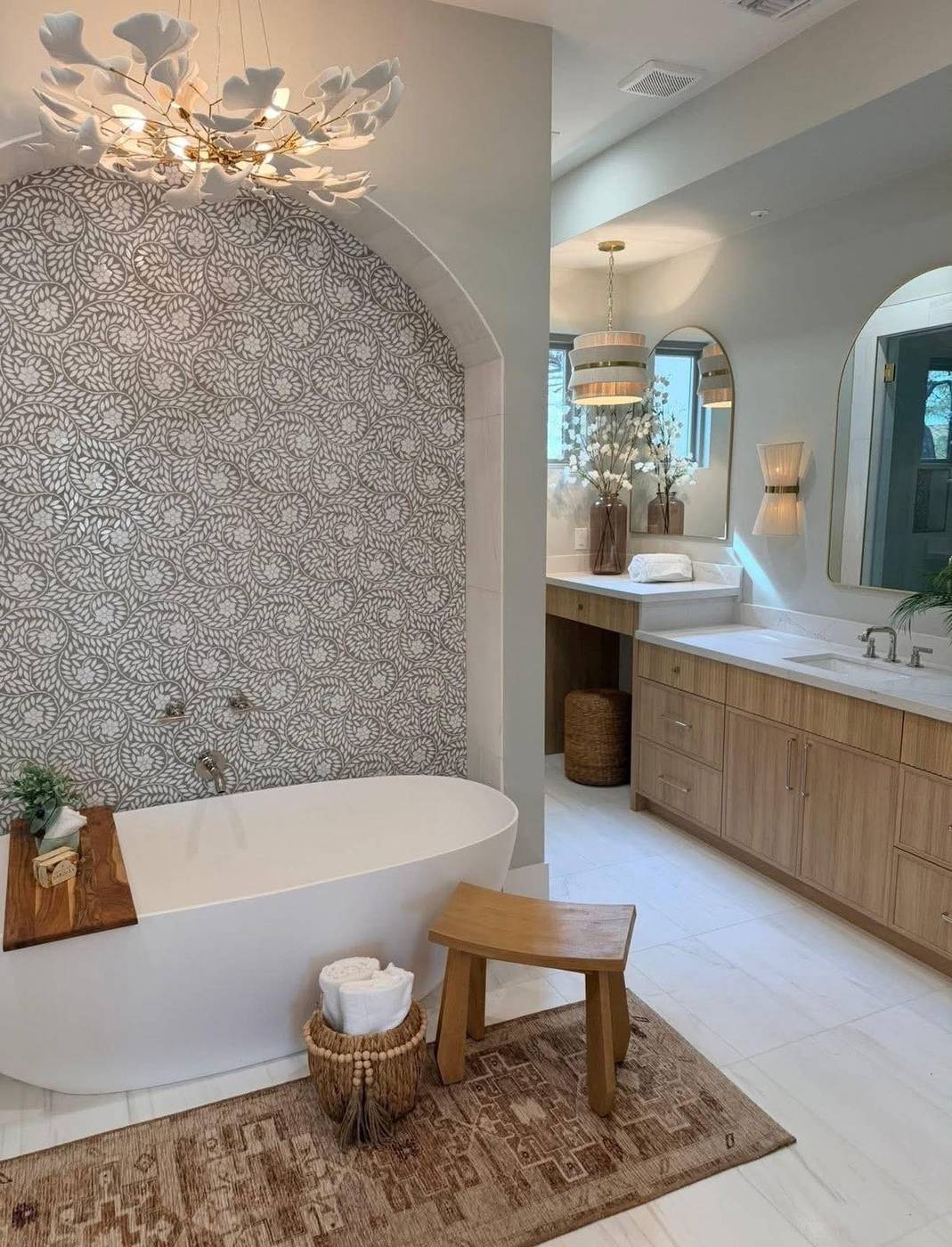 Primary bathroom staged with a freestanding soaking tub in a tiled arch alcove