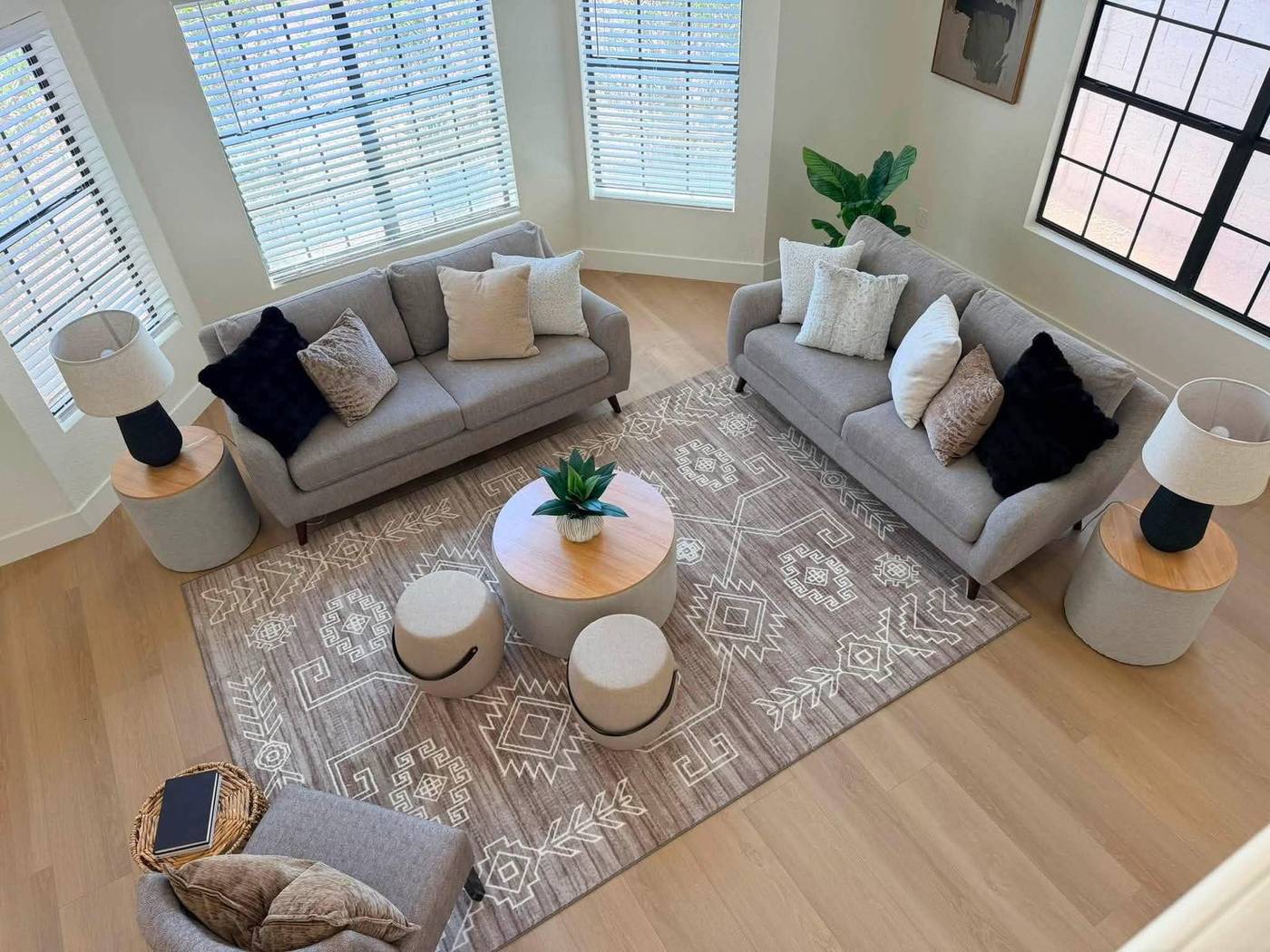 Sitting room staged with two facing sofas, round drum tables and a wool rug Sitting room staged with two facing sofas, round drum tables and a wool rug